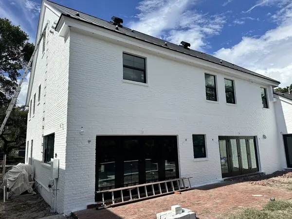 Two-story house with painted white brick and black-framed windows